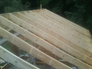 New roof rafters set over an addition before sheathing in Suffield