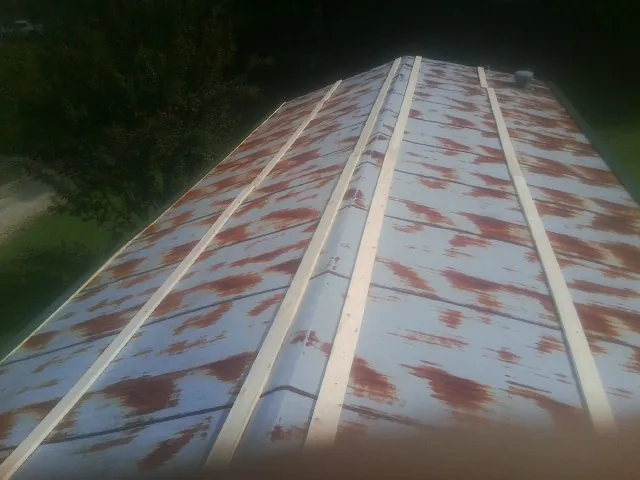 Rusted metal roof panels with new wood purlins before replacement — Storm Damage Roof Repair in Suffield by Roofing Brothers