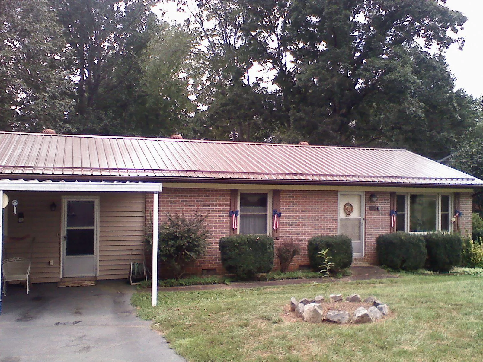 Bronze metal roof and carport on a brick ranch home — Roof Repair work by our crew in Suffield